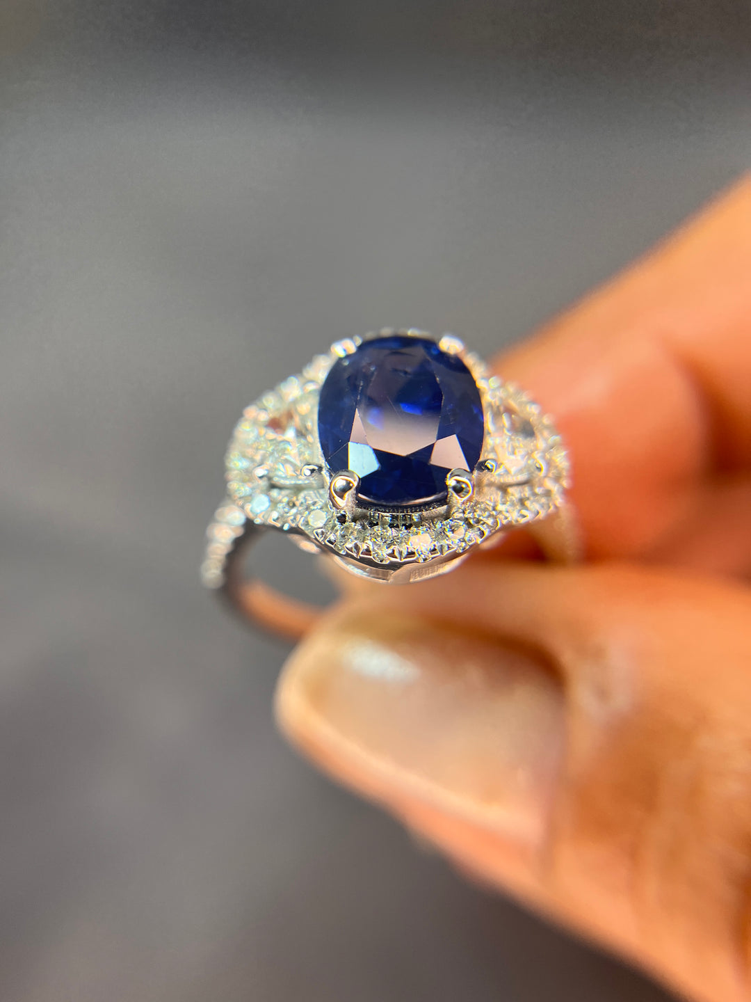 Halo Design 2 Ct. Tw. Oval Cut Natural Blue Sapphire with 1.25 Ct. Tw. Half Moon and Round Cut Side Diamond Ring